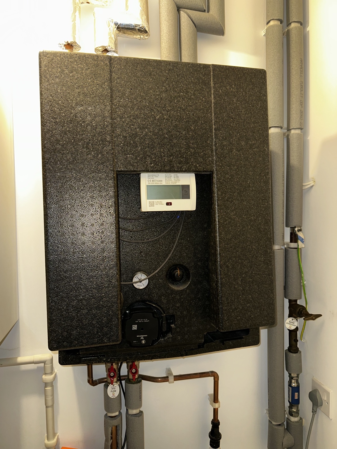 Heat interface unit with insulated casing, heat meter and circulation pump