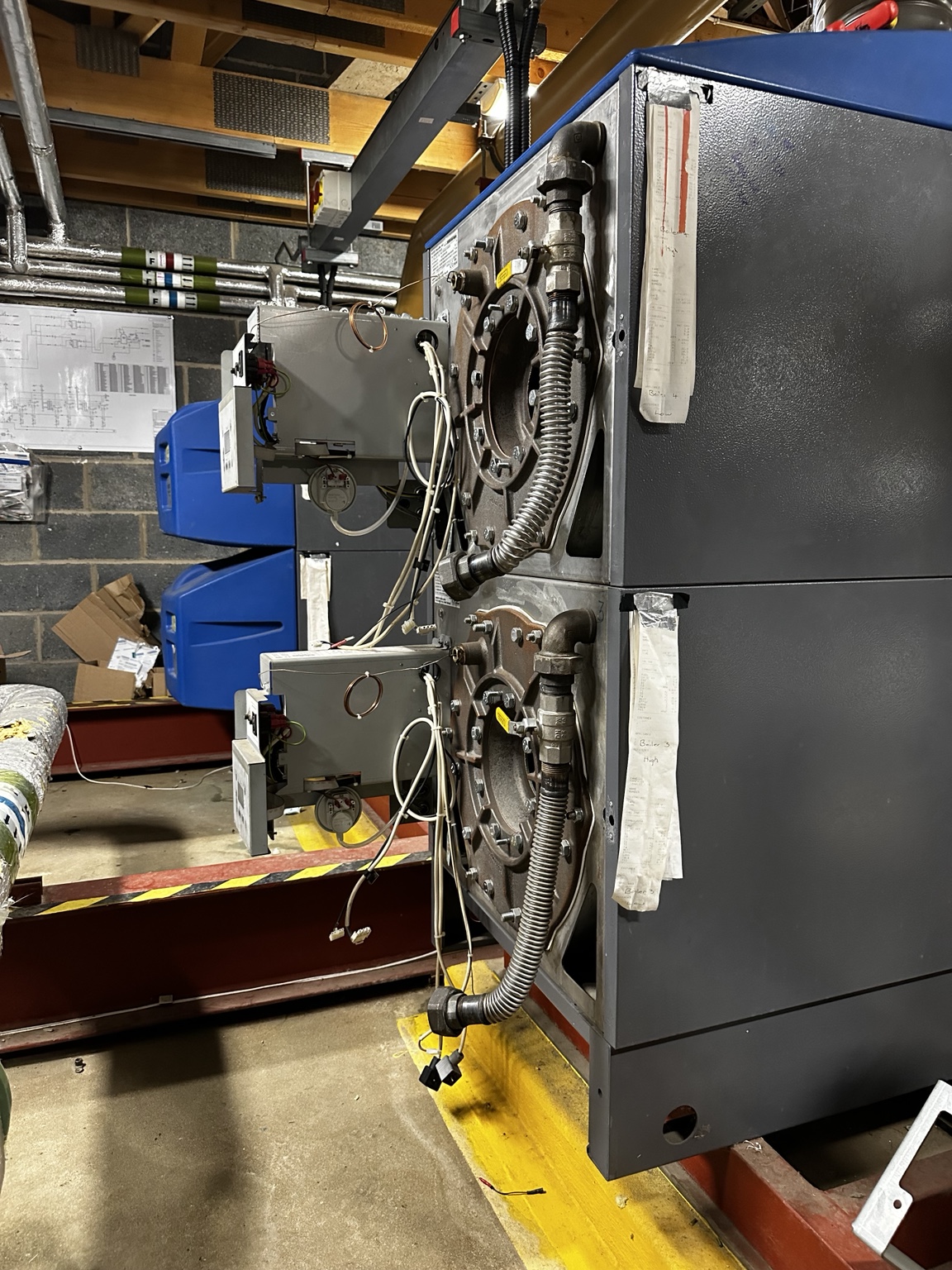 Commercial boilers with front covers and burner assemblies removed during work